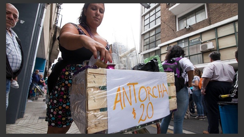 Una vendedora aprovecha para vender antorchas en la marcha en Rosario. 