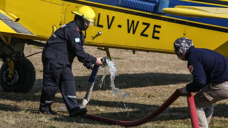 Bomberos cargan agua a un avión hidránte en el predio del club de Planeadores ubicado en Alvear. 