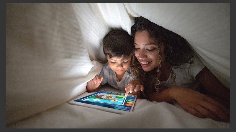 Mother and son playing on a digital tablet in bed