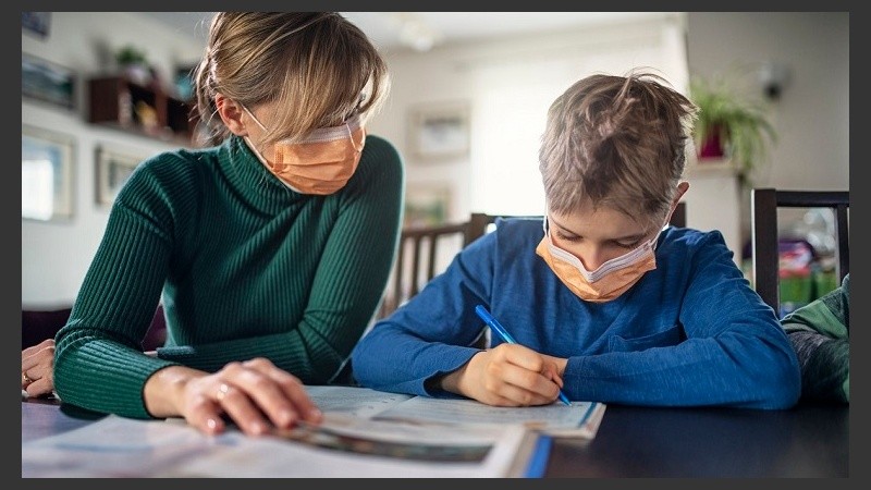 Mother homeschooling her son wearing face masks
