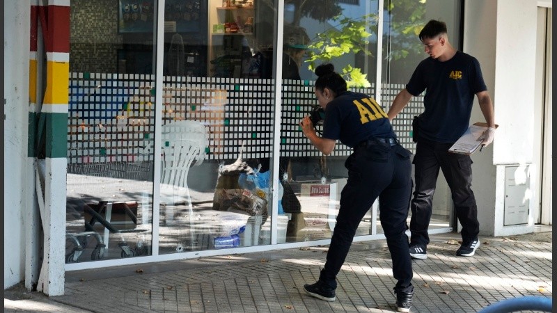 Personal policial constata las marcas que dejaron los balazos contra el super. 