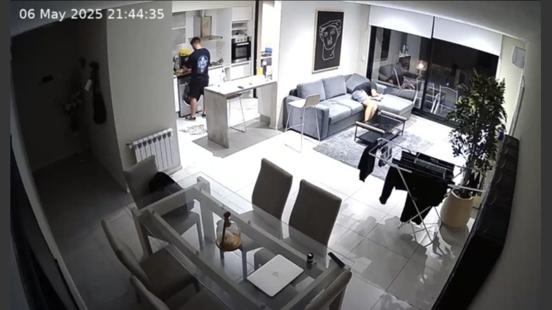 La víctima aparece recostada y dormida en el sillón, mientras el presunto autor del robo está en la casa.