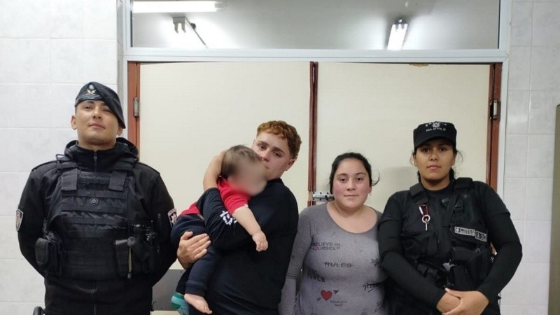 El bebé junto a sus padres y los agentes policiales que acudieron al rescate.